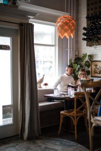 Two people sitting at a table in KaiserHaus Wine Bar & Bistro on a cozy date.