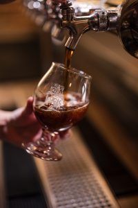 A beer being poured into a branded Lock St. Brewing Co. glass.