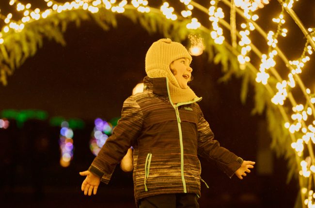 A smiling child enjoying the Let it Glow - A Celebration of Light festival in St. Catharines.